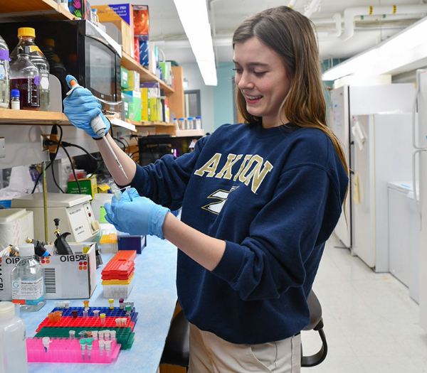A woman holds a test tube, focused on her scientific work in a laboratory setting.